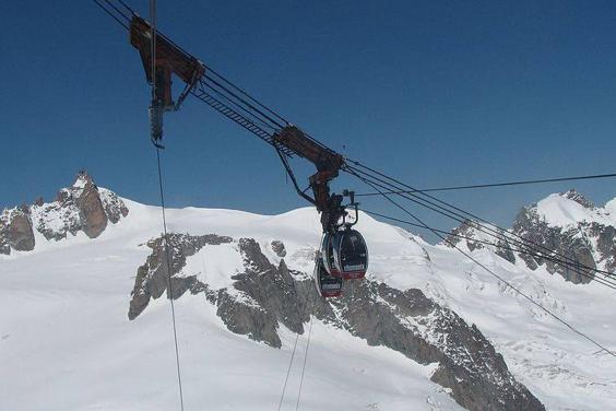 Cable-cars over a snow-covered mountain.