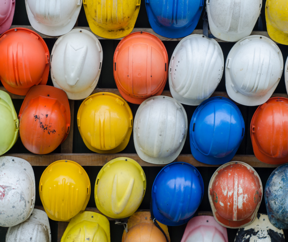 A collection of different coloured hard hats.