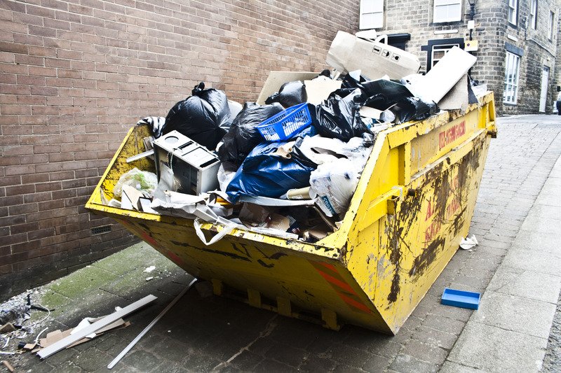 A yellow skip full of rubbish.