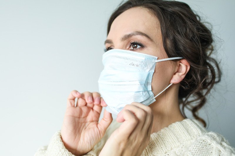 A woman wearing a surgical face mask.
