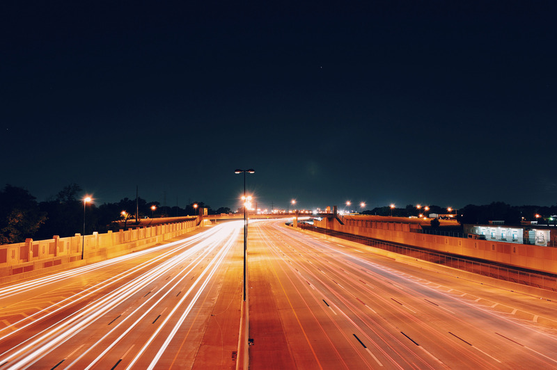 A brightly-lit motorway against the night sky.