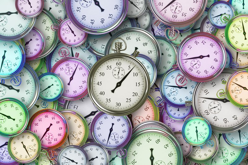 Different coloured stop watches piled together.