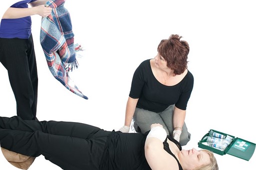 Two women who are treating another women who is in shock.