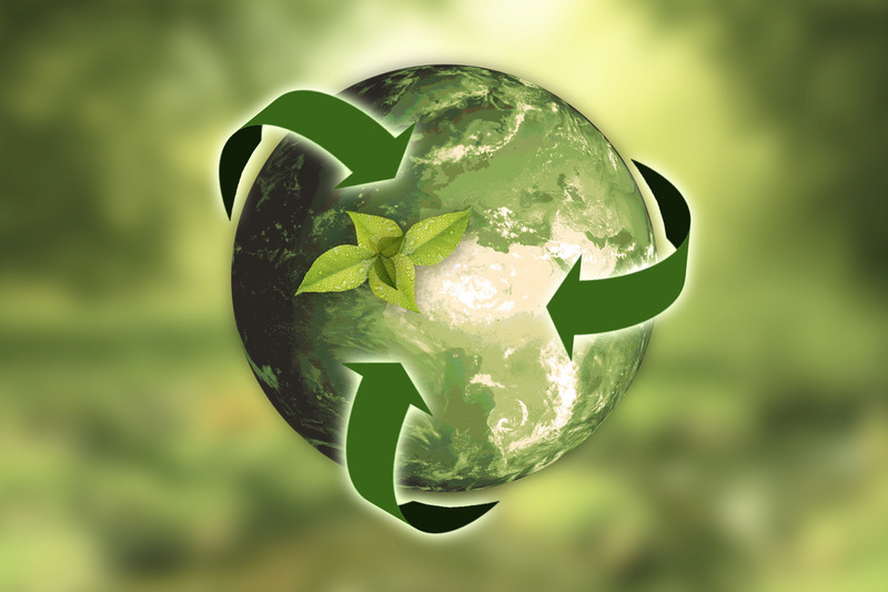 A green Earth with recycling arrows around it and a plant growing on top of it.