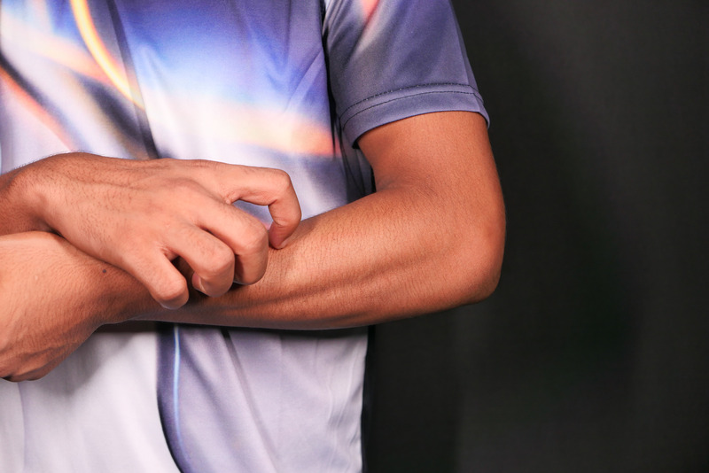 A person itching their skin.