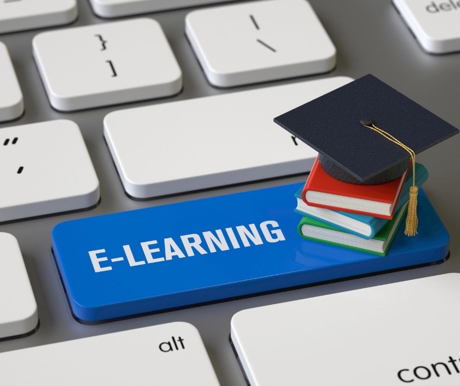 Computer keyboard with a key that says 'E-learning'. On the key is a small stack of books and a graduation cap