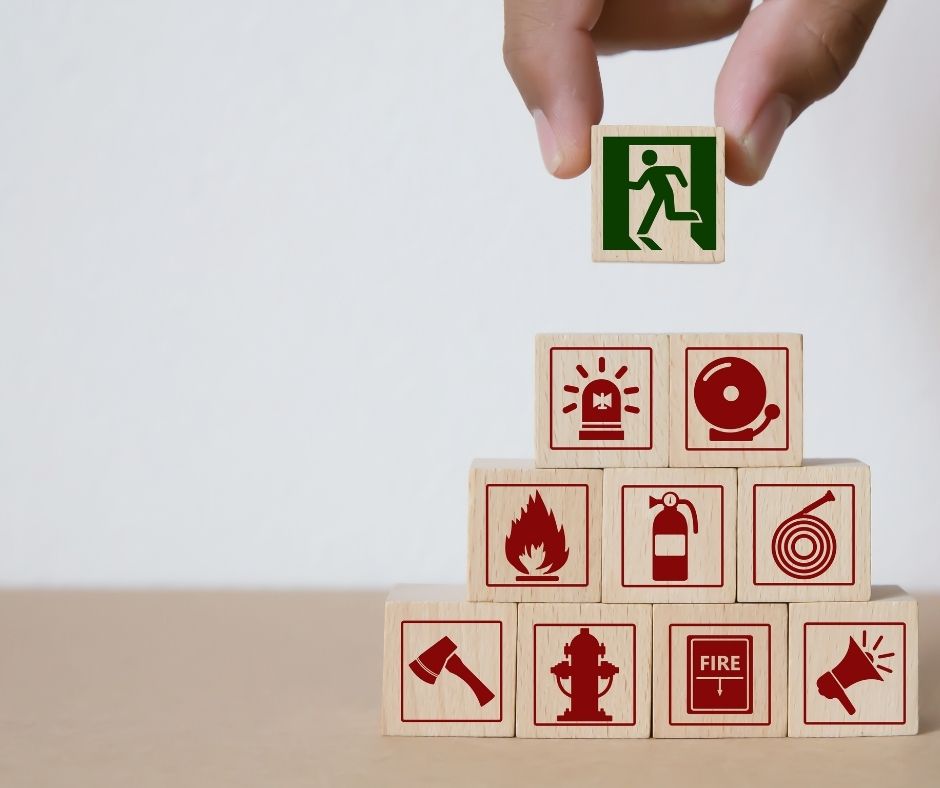 Small wooden blogs stacked up, each with a fire safety symbol on it