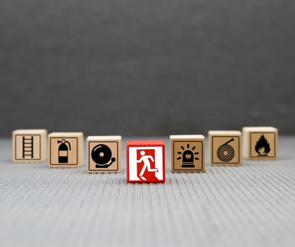 Fire safety related icons (e.g fire door, flame etc) on small wooden blocks