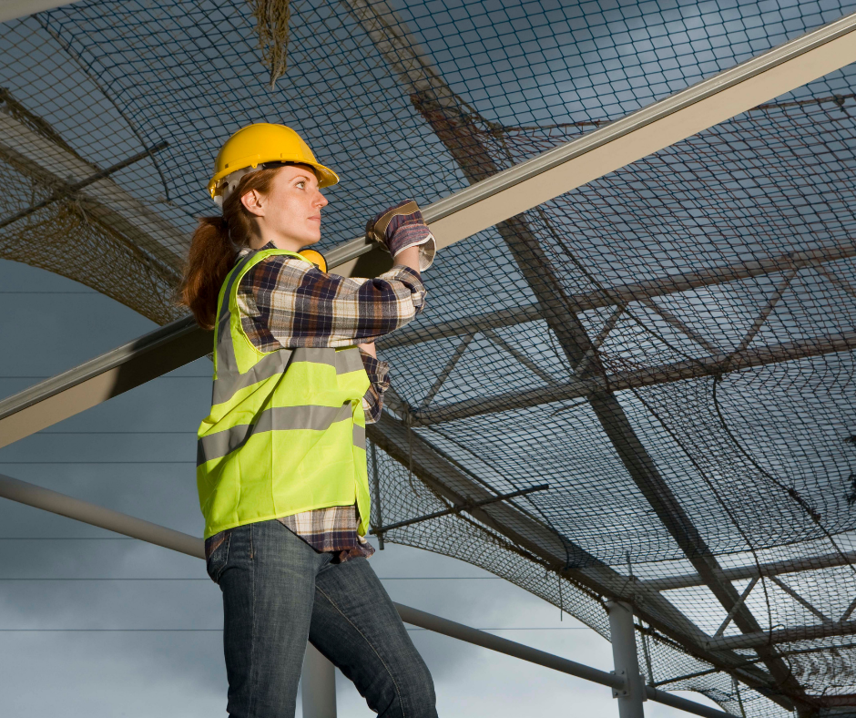 Construction worker carrying a metal beam
