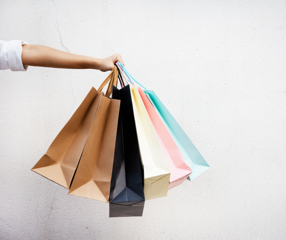 hand holding paper shopping bags