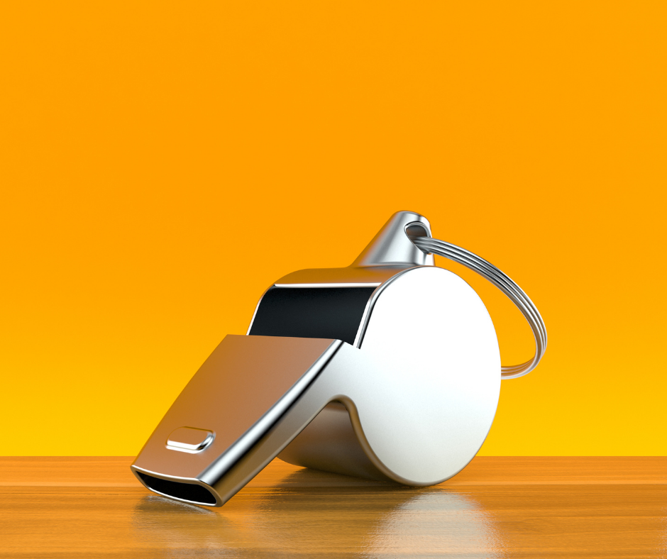 Silver whistle against a yellow background