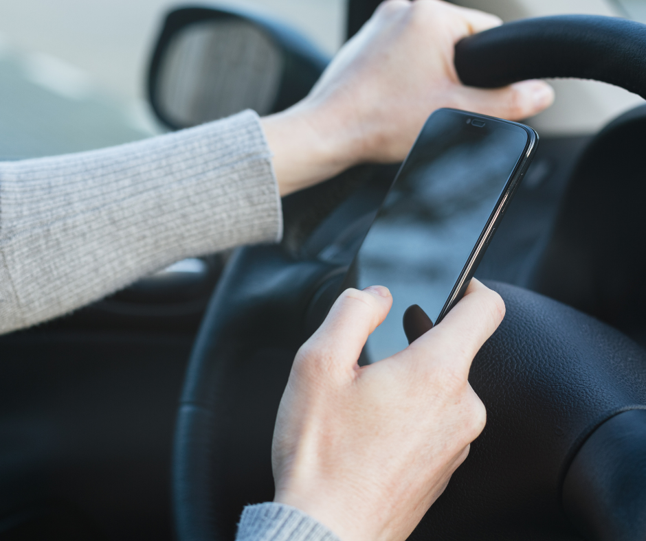 person holding a mobile phone while driving