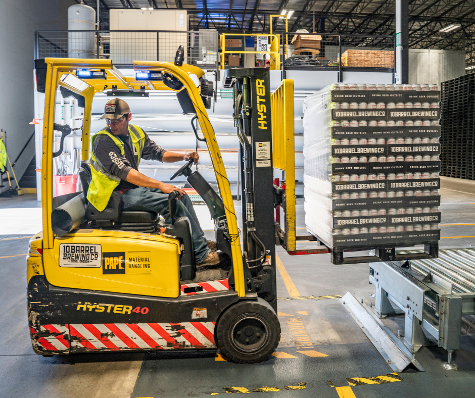 Man in warehouse driving a forklift