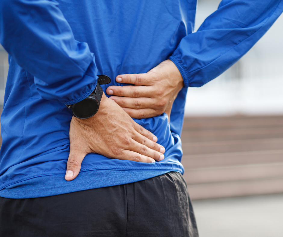 Close up of a man holding his lower back in pain