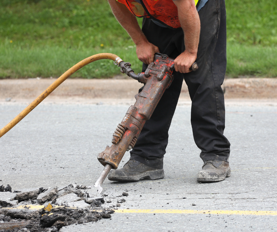 Road construction worker using a pneumatic jackhammer