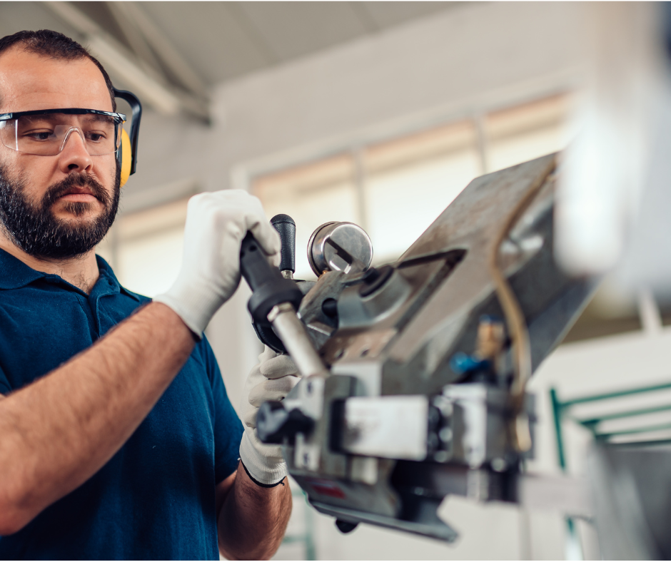 factory worker operating band saw cutting machine 