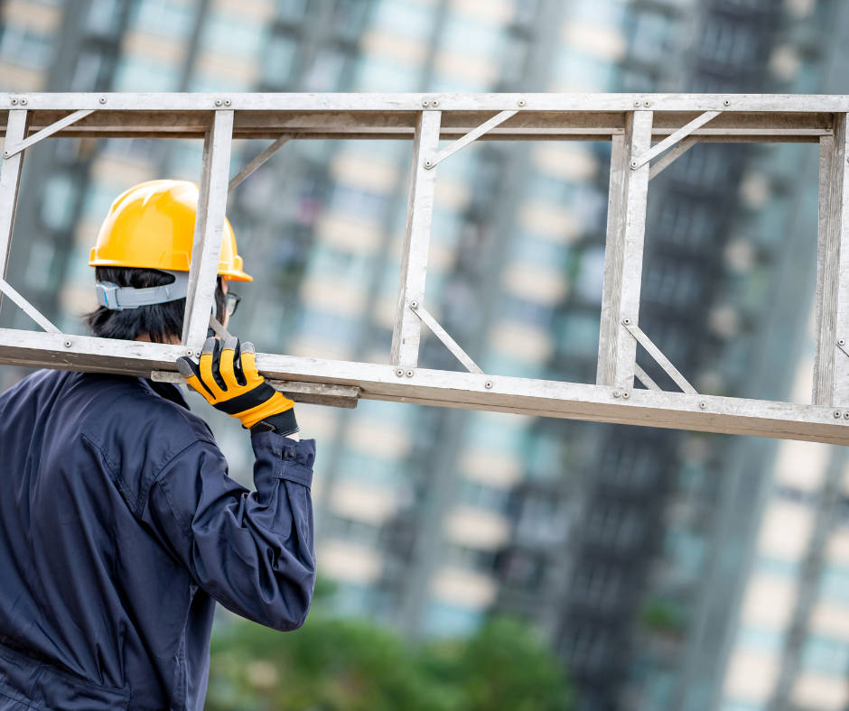 Worker holding a ladder over his shoulder