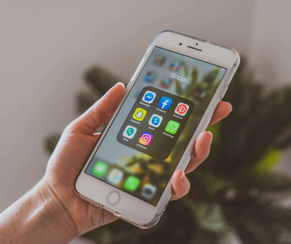 hand holding a phone displaying apps