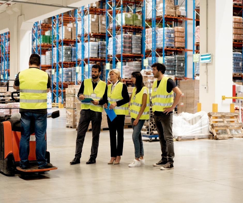Group of trainees in a warehouse wearing hi vis