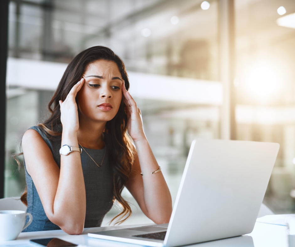 Woman sat at laptop looking stressed