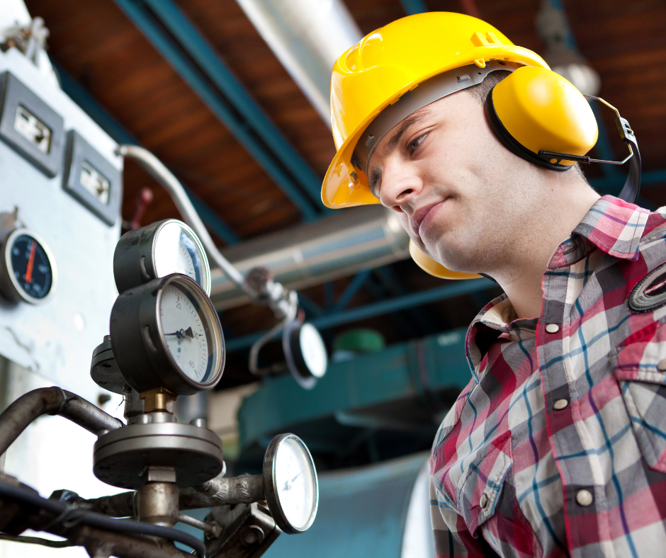 Worker wearing a hard hat and ear defenders