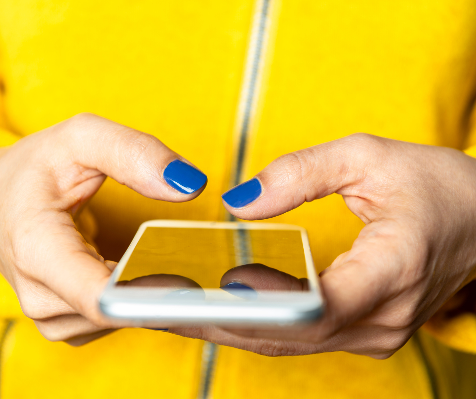 Close of of hands using a mobile phone