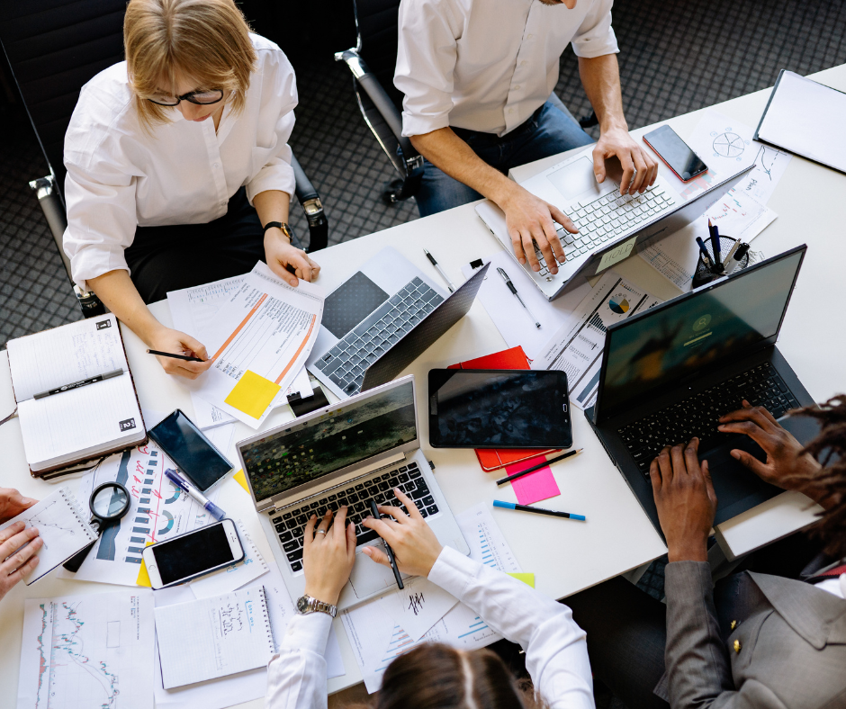 four colleagues working at a desk together