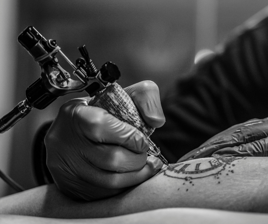 black and white photo of someones arm being tattooed