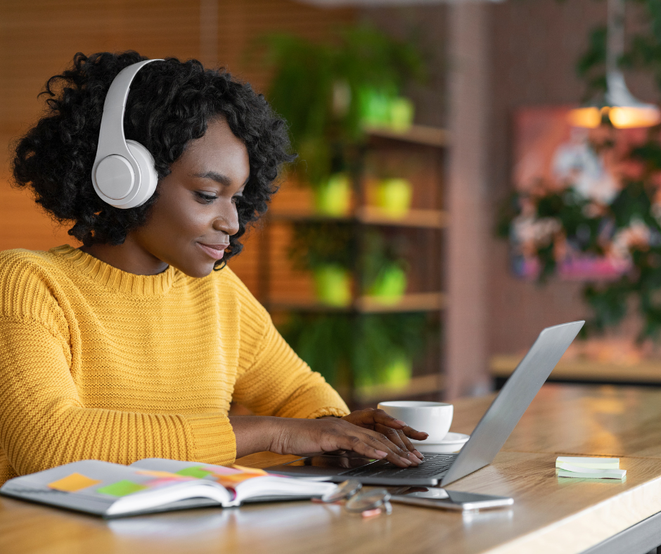 woman sat at her laptop with headphones on