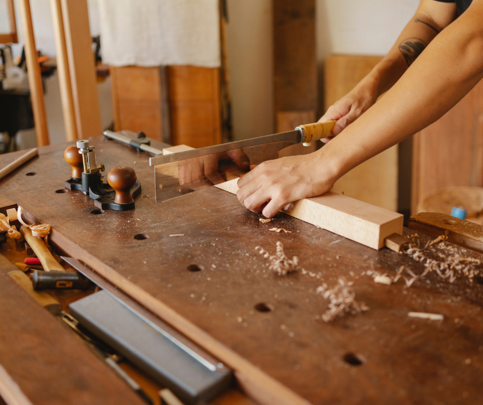 Person sawing a piece of wood